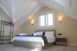 a bedroom with a large bed with a window at Zeus Cosmos Apartments in Lourdata
