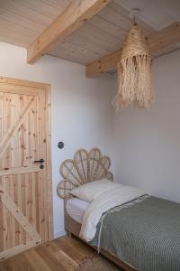 a bedroom with a bed and a wooden door at Tropianka - sielski dom na skraju wsi in Tropie