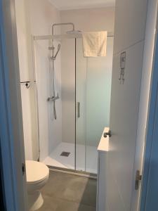 a bathroom with a toilet and a glass shower at Alojamiento El Cantal in Santoña +96 photos