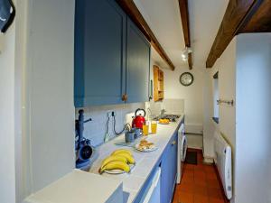 a kitchen with blue cabinets and yellow towels on the counter at 2 Bed in Blaenau Ffestiniog oc-86064 in Maentwrog +10 photos