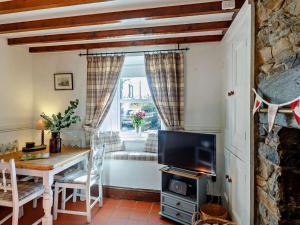 a living room with a table and a television at 2 Bed in Blaenau Ffestiniog oc-86064 in Maentwrog