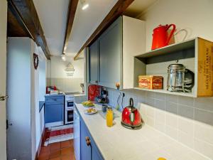 a kitchen with blue cabinets and a red kettle on the counter at 2 Bed in Blaenau Ffestiniog oc-86064 in Maentwrog