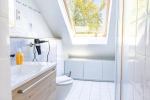a bathroom with a sink and a toilet and a window at Lago Edera - Seeblick in Hemfurth-Edersee +37 photos