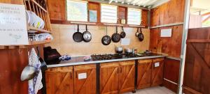 a kitchen with wooden cabinets and a stove at Agrocamping Invernaderito in Tejina