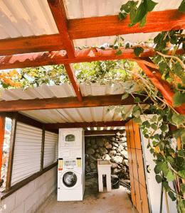 a washing machine sitting under a wooden roof at Agrocamping Invernaderito in Tejina +34 photos