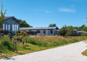 a house with a garden next to a road at Penmarlam Lodge Retreat in Fowey