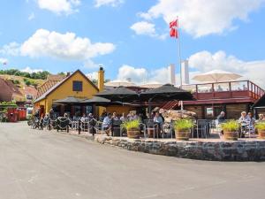 a group of people sitting at an outdoor restaurant at 5 person holiday home on a holiday park in Gudhjem in Gudhjem