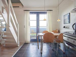 a dining room with a table and chairs and a window at 5 person holiday home on a holiday park in Gudhjem in Gudhjem