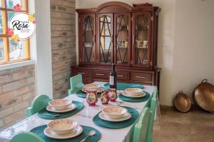 una mesa con sillas verdes y un armario de madera en Santa Rosa de Lima Hostal Zuleta en Hacienda Zuleta