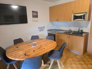 a kitchen with a wooden table with chairs around it at Apartments Rozle in Kranjska Gora +20 photos