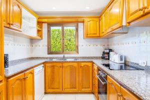 a kitchen with wooden cabinets and a window at Llenaire Gran Beach House in El Port