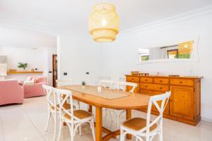 a kitchen and dining room with a wooden table and chairs at Llenaire Gran Beach House in El Port