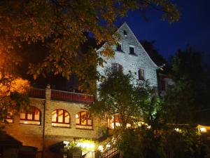 duży kamienny budynek w nocy z oświetleniem w obiekcie Drachenburg w mieście Marktbreit