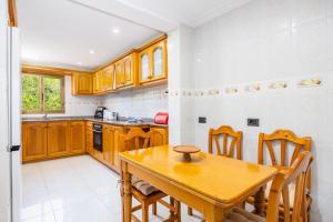 a kitchen with wooden cabinets and a wooden table at Llenaire Gran Beach House in El Port