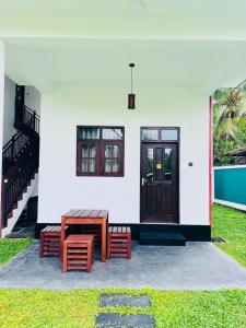 a building with two benches and a wooden door at Hotel Elysian in Udawalawe
