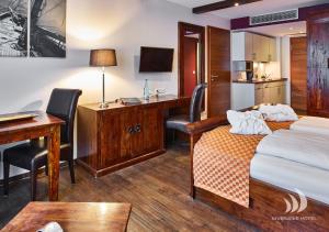 a hotel room with a bed and a desk and a computer at Riverside Hotel in Nordhorn