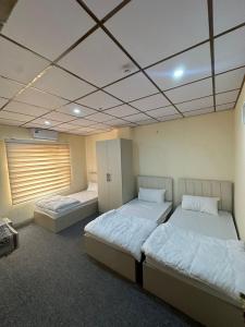 a room with two beds in a room at Iraq palace apartment in As Sulaymānīyah