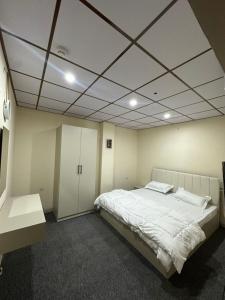 a bedroom with a large white bed and a ceiling at Iraq palace apartment in As Sulaymānīyah