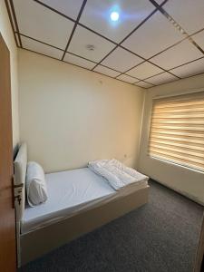 a bedroom with a bed in a room with a window at Iraq palace apartment in As Sulaymānīyah