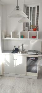 a white kitchen with a sink and a microwave at pardelo in Adeje