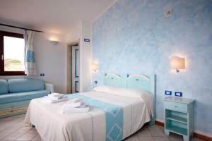 a blue bedroom with two beds and a couch at La Locanda del Mare in Codaruina