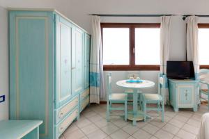 a blue room with a table and a table and a tv at La Locanda del Mare in Codaruina