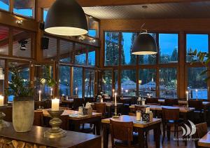 a restaurant with tables and chairs and large windows at Riverside Hotel in Nordhorn