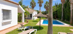 a yard with a swimming pool and a house at Andalusian patio villa 12 pax with private pool in Conil de la Frontera