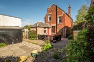 an old brick house with a fence in front of it at Heywood Cottage in St. Andrews