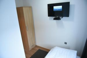 a room with a tv on the wall and a bed at Motel Alibi in Banja Luka