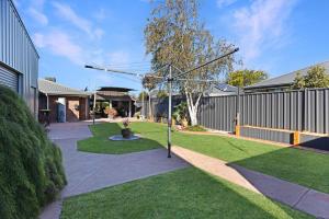 a garden with a tree in the middle of a yard at Maffra Retreat in Maffra