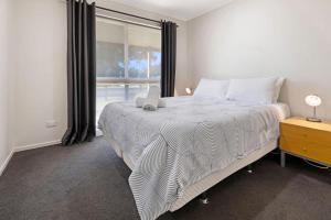 a bedroom with a large bed and a window at Maffra Retreat in Maffra