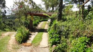 een pad in een tuin met een houten brug bij Refúgio do Azzi in Monte Verde