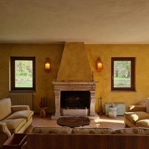 a living room with a fireplace and two couches at Casale Pomodoro in Manziana