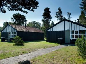 two buildings in a yard with trees at 6 person holiday home in Væggerløse in Bøtø By