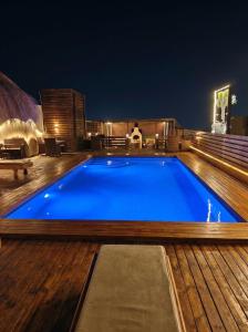 a large blue swimming pool on a deck at night at Soly Apartments in Hurghada