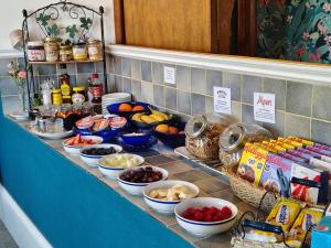 a counter with many bowls of food on it at River Hotel in Oxford