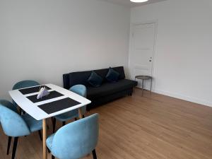 a living room with a couch and a table and chairs at CityZen Apartment CpH in Copenhagen