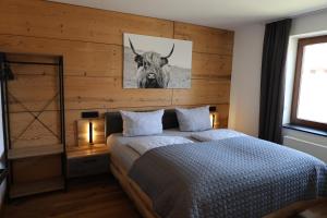 a bedroom with a bed with a bull painting on the wall at Ferienapartment Horn in Altendorf