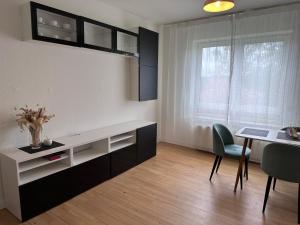 a living room with a desk and a table and chairs at CityZen Apartment CpH in Copenhagen