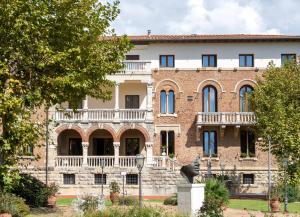 an old brick building with a large balcony at Park Hotel Villa Ariston in Lido di Camaiore