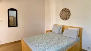 a bedroom with a bed with a mirror on the wall at Villa Keur Lune - Saly - SENEGAL in Saly Portudal +20 photos