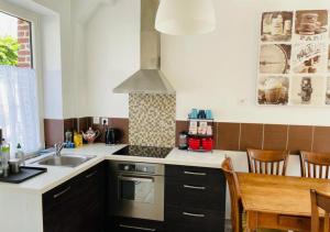 a kitchen with a sink and a stove top oven at Maison de pêcheur in Étretat