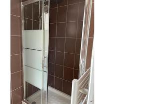 a shower with a glass door in a bathroom at Maison de pêcheur in Étretat