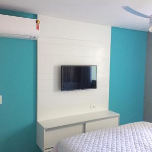 a bedroom with a bed and a tv on a wall at Flat Carneiros Beach Resort in Tamandaré