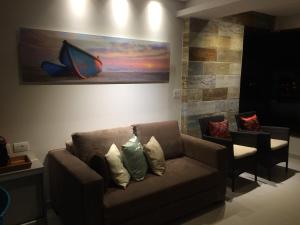 a living room with a couch and a painting on the wall at Flat Carneiros Beach Resort in Tamandaré