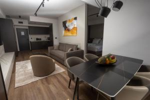 a dining room and living room with a table and chairs at Hotel Cube 55 - Business Suites in Skopje