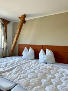 a large bed with two pillows on top of it at Familienbett und Sauna - Muschelbude in Wittenbeck