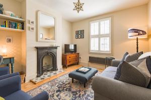 a living room with a fireplace and a tv at Star Cottage in Whitstable