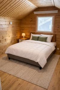 a bedroom with a large bed in a wooden wall at Holiday Cabin Naalinpesä incl Wifi, outdoor jacuzzi for extra fee in Äkäslompolo